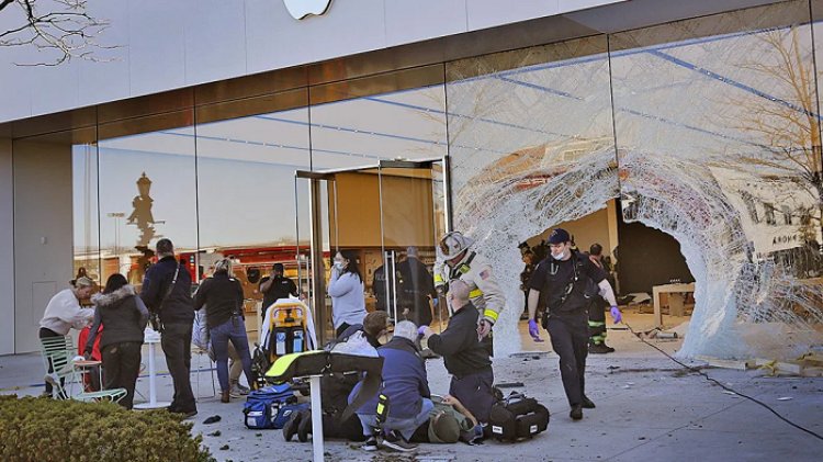 Petugas penyelamat merawat orang yang terluka di depan toko usai insiden. (Greg Derr/AP)